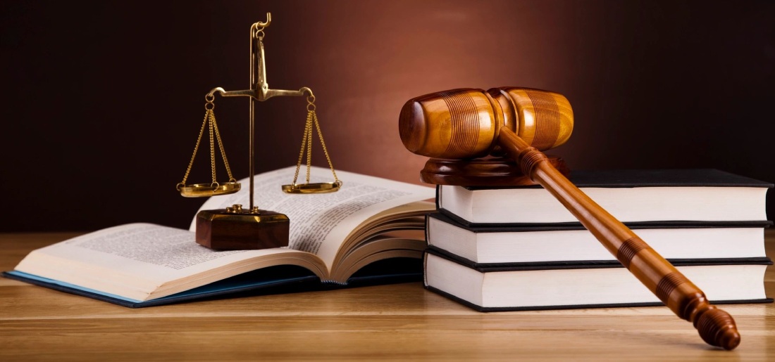 A judge 's gavel and scale on top of books.